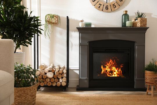 Serviced fireplace burning beside a rack of split logs